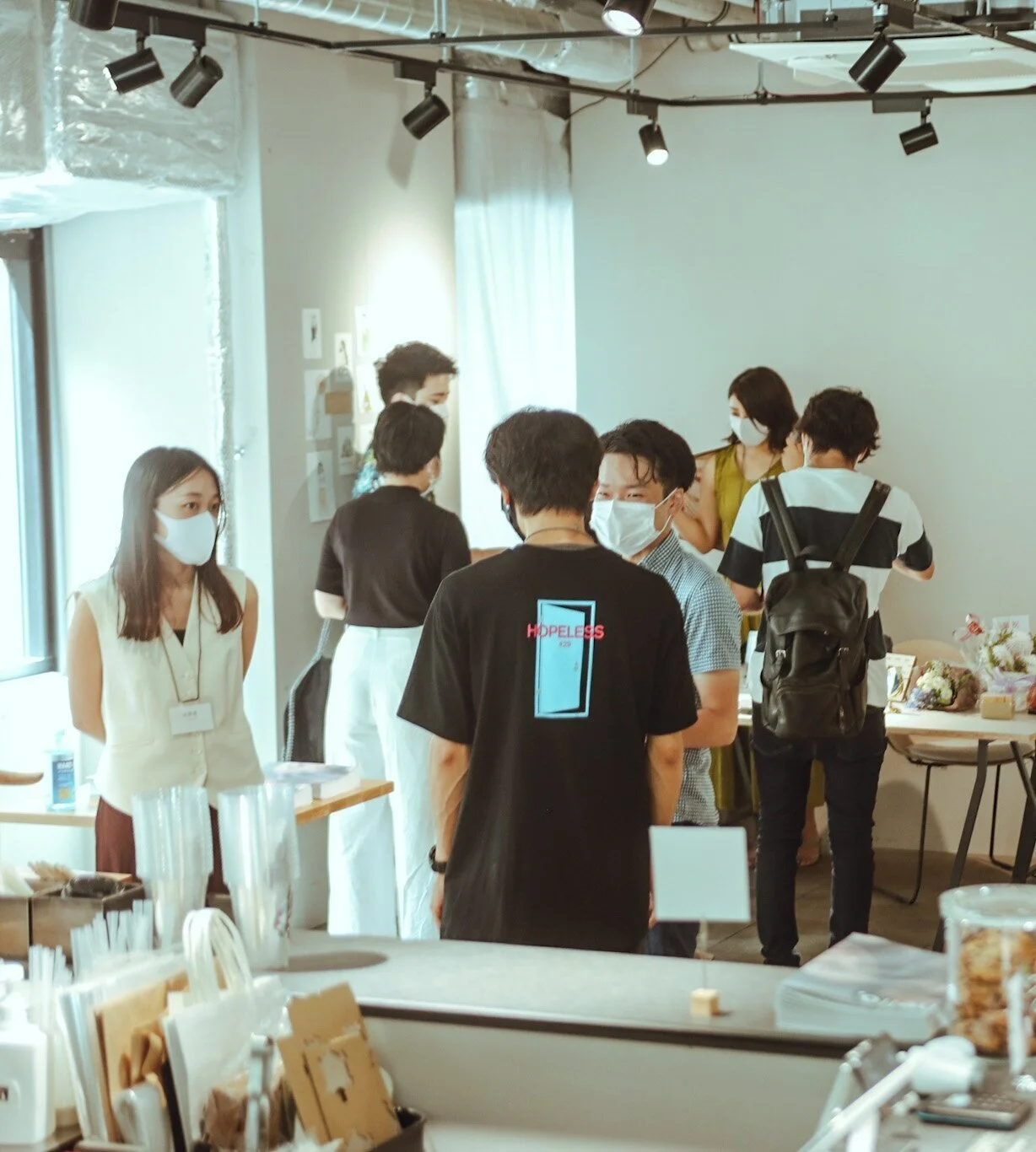 OPEN NAKAMEGUROの窓際で作品と会話を楽しむ人々