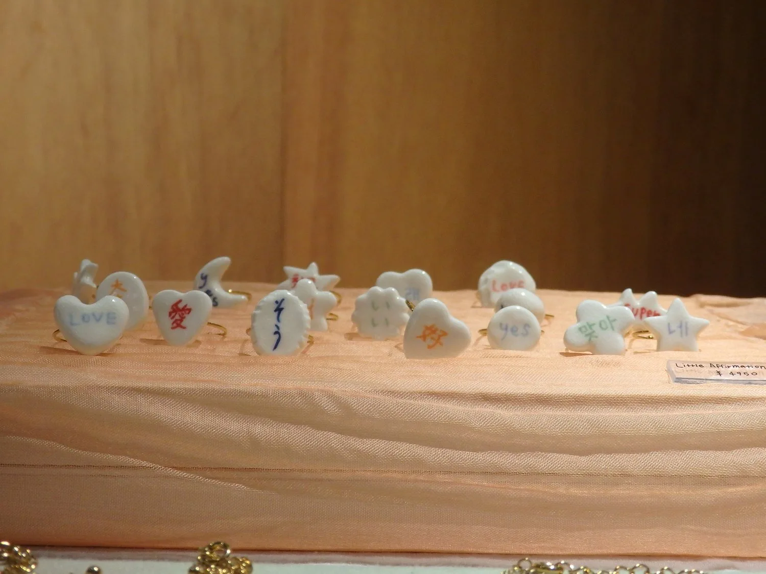 RE:ENに出店した小林ななこの、小さな陶器の作品が木の展示台に並ぶ様子