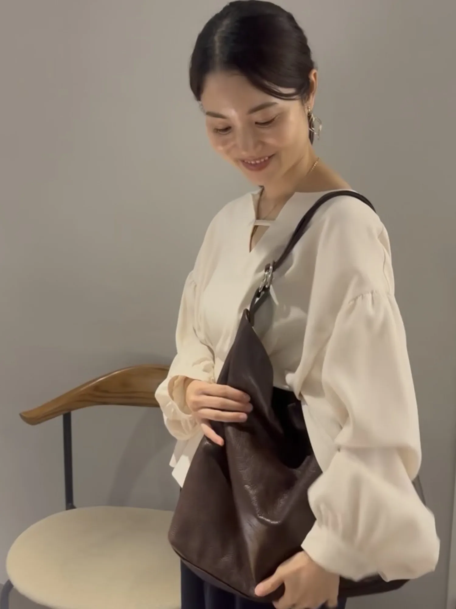 OPEN NAKAMEGUROのRE:ENで、Écelのバッグを手に取り服に合わせる人